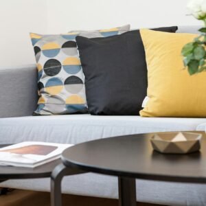 Contemporary living room interior featuring a stylish sofa, decorative pillows, and a vase of flowers.